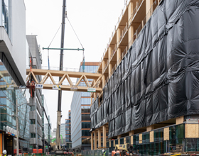 PCL installs mass timber pedestrian bridge at GBC's Limberlost Place 