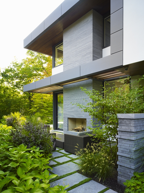 This Toronto residence’s backyard includes terraces, a deep ravine, and fireplace area.