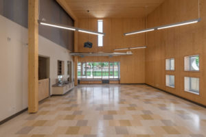 A common area within the childcare centre with its high mass timber ceilings and windows of various formats.
