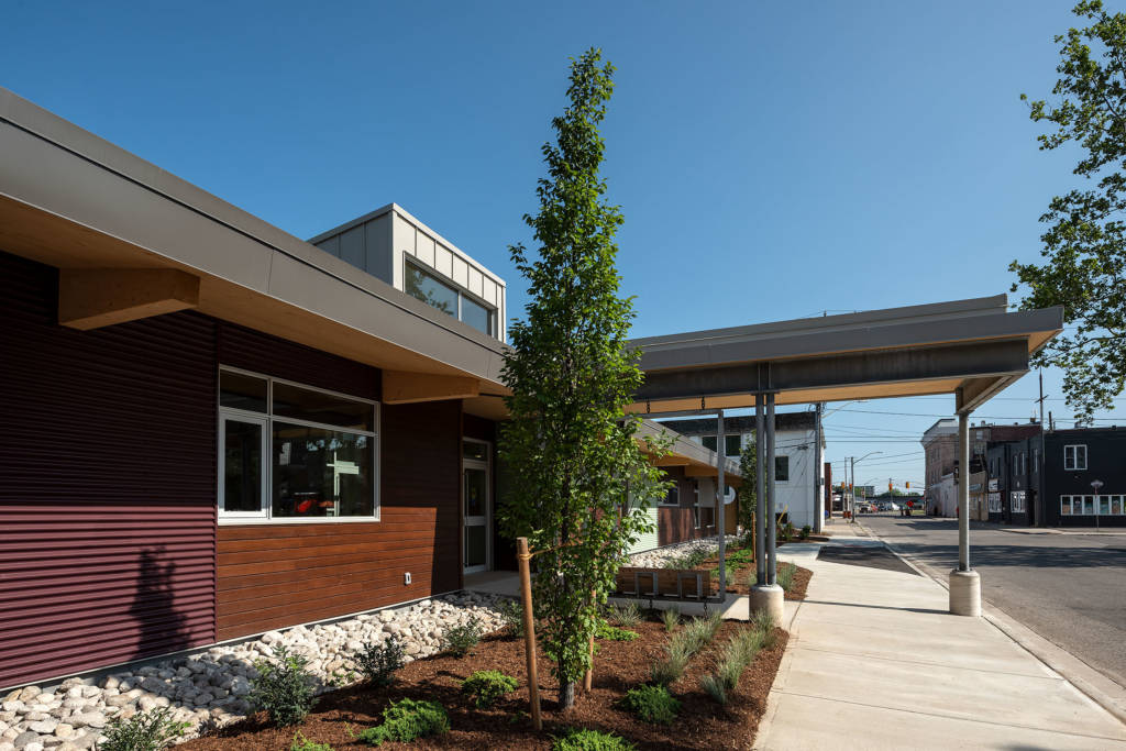 The canopy at the entrance. The wood and metal siding is evident on the facility’s facade.