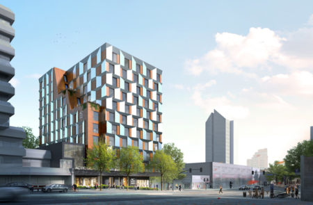 Modern hotel with a unique geometric facade in an urban setting.
