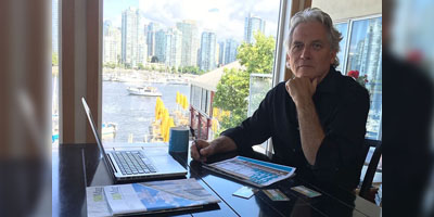 man sitting near a laptop on a desk