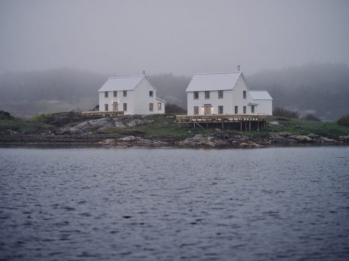saltbox house in the middle of a water body with hazy atmosphere
