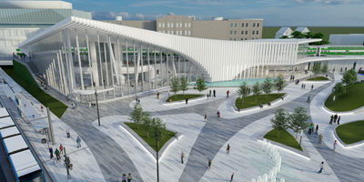 Architectural rendering of a modern transit hub featuring a sleek, curved glass facade with vertical white fins. The outdoor plaza includes autumn-colored trees, a water feature, and people walking and cycling.