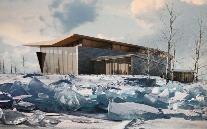 A modern architectural building with a slanted roof and large glass windows, set in a winter landscape with icy blue frozen formations in the foreground.