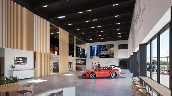 Luxury car showroom with high ceilings, large windows, and sleek interior design featuring a red sports car on display.