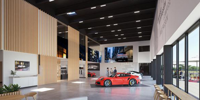 Luxury car showroom with high ceilings, large windows, and sleek interior design featuring a red sports car on display.