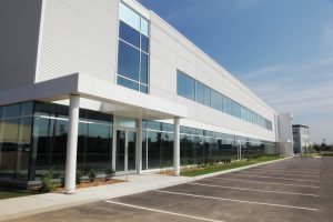 A sleek industrial building, with its pristine white facade and expansive windows.