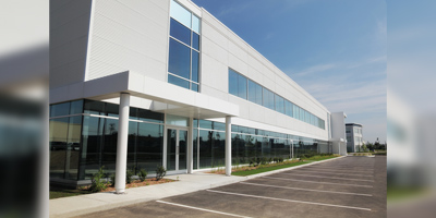 A sleek industrial building, with its pristine white facade and expansive windows.
