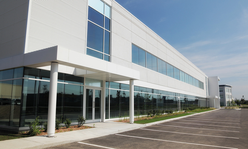 A sleek industrial building, with its pristine white facade and expansive windows.
