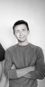 Black and white headshot of a man in a sweatshirt.