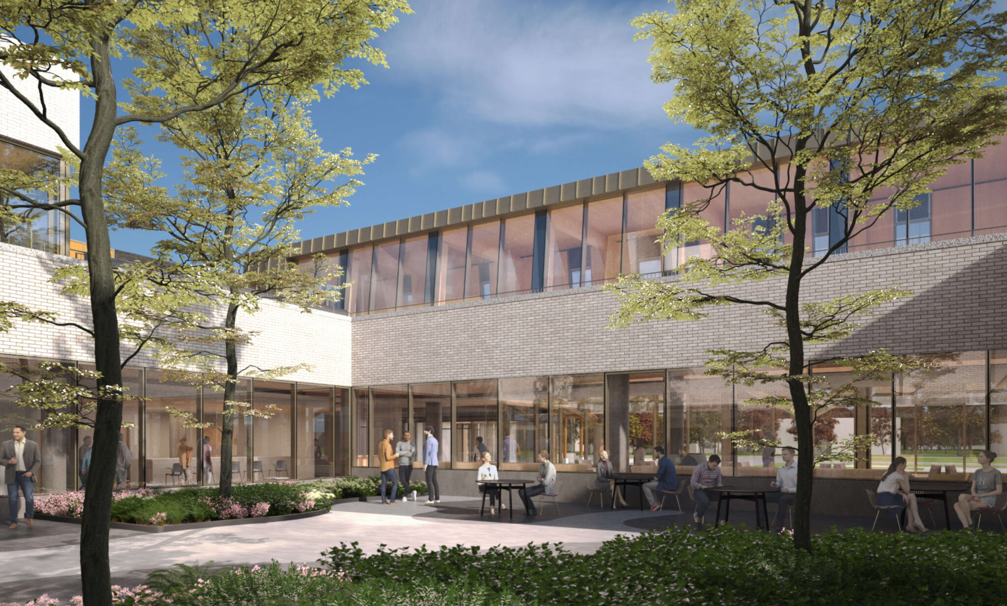 A modern courtyard surrounded by glass-walled buildings, with people seated at tables and lush greenery. Bright blue sky overhead.