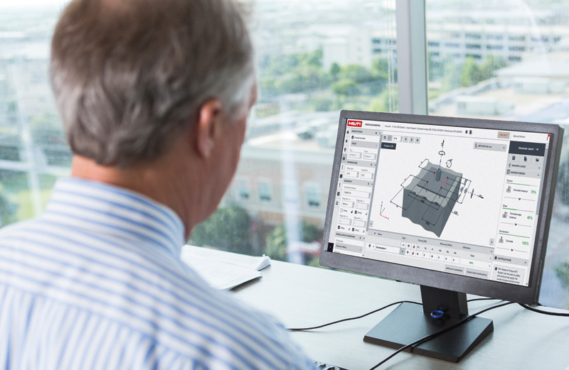 A man in a striped shirt views a design software on his computer, focusing on a 3D model of a building component.