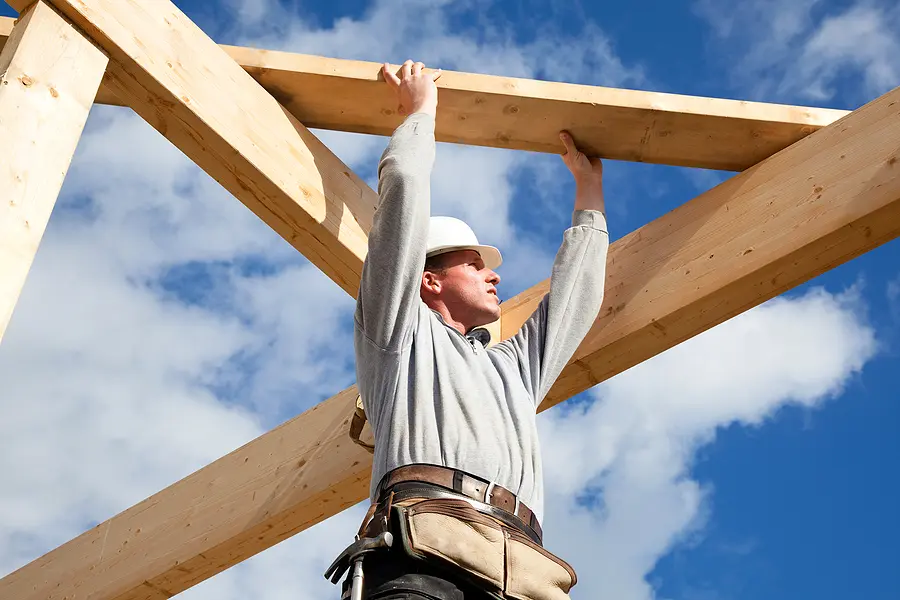 carpenter at work with wooden roof construction