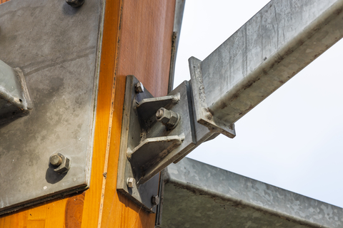 Close up view of steel bracket joining a glulam timber column and beam