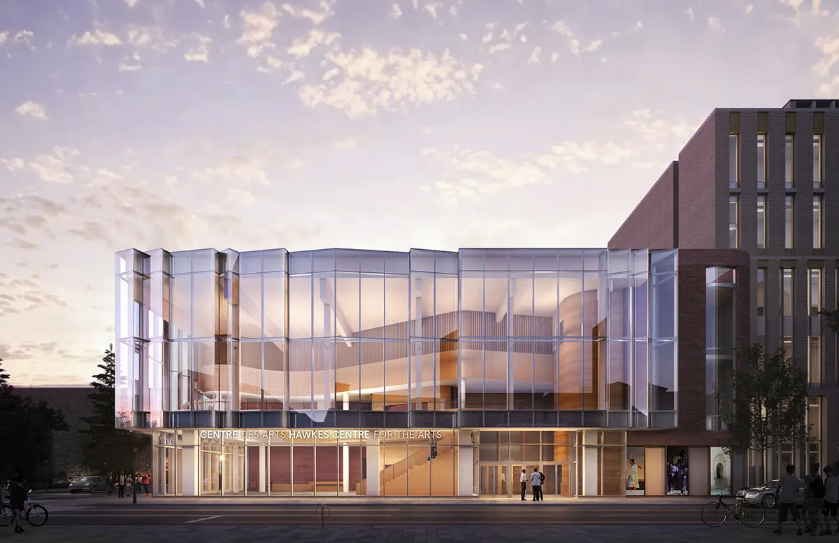 Modern architectural design of the Hawkes Centre for the Arts, featuring large glass panels and a warm entrance, set against a twilight sky.