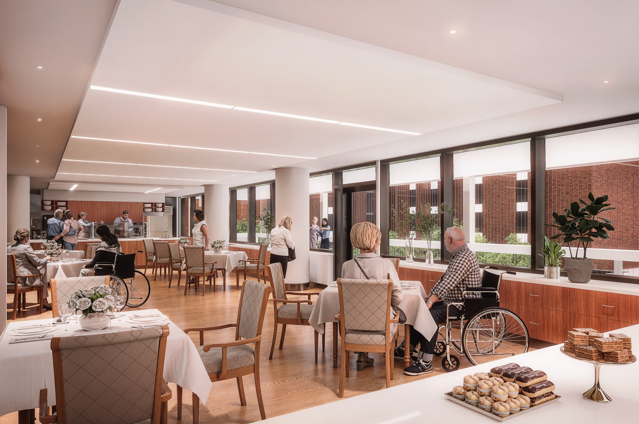 Spacious, sunlit dining area with people eating, chatting, and a serving counter, featuring wooden floors and large windows overlooking a brick exterior.