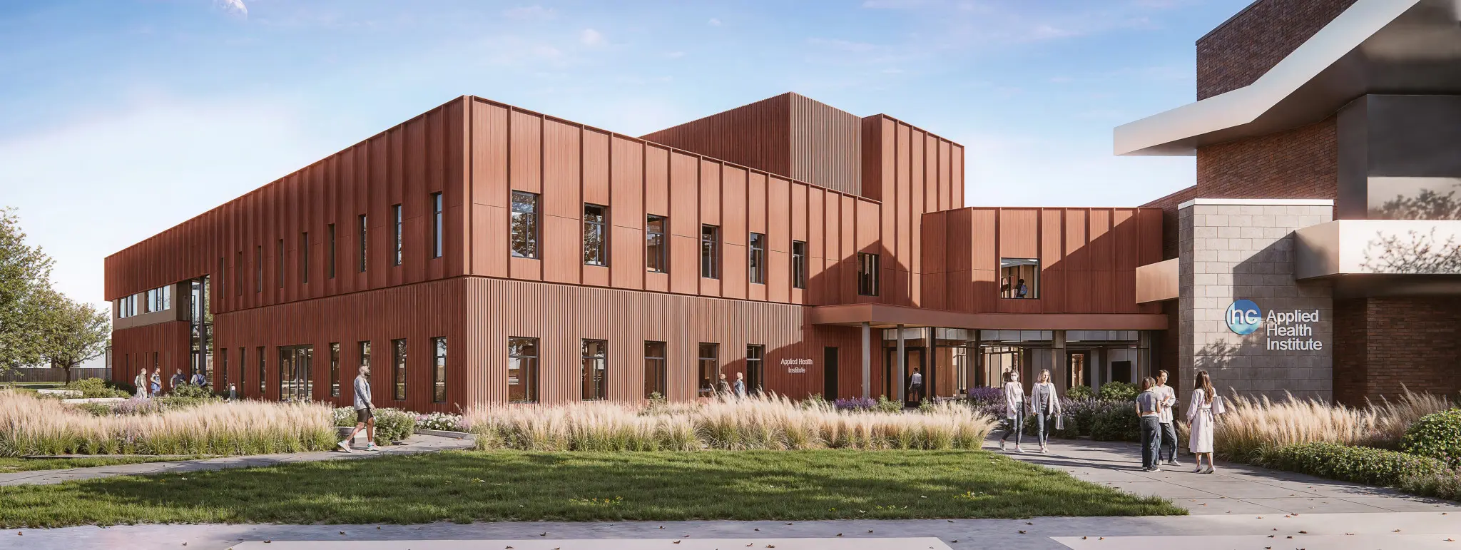 Modern brick building under a clear sky, with large windows and a welcoming entrance surrounded by greenery. People are walking and socializing.