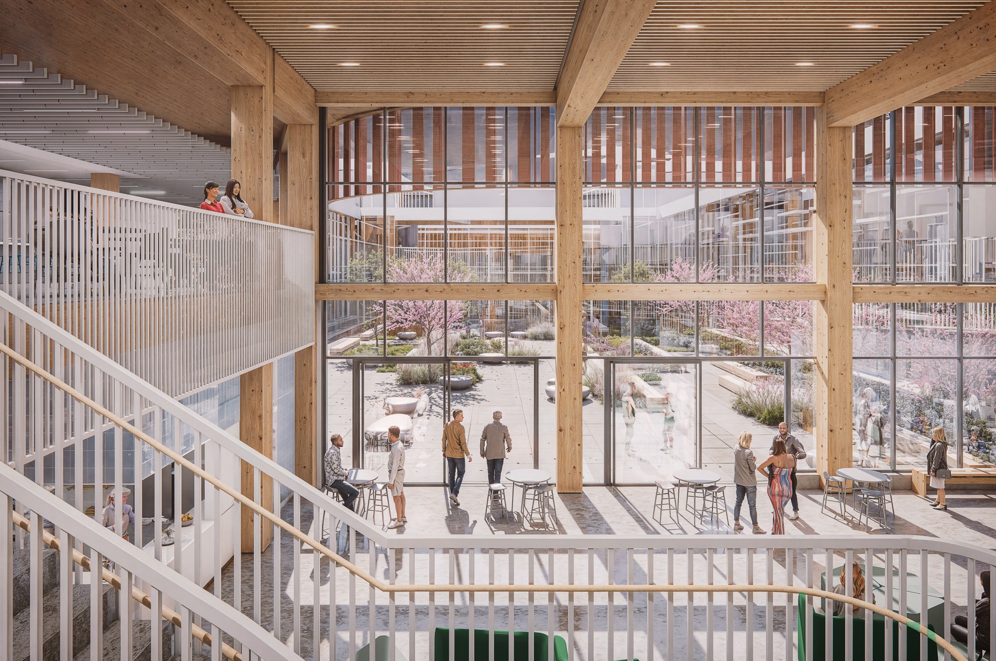 A spacious, modern atrium with large wooden beams and glass walls reveals a bright courtyard filled with greenery and people engaging casually.