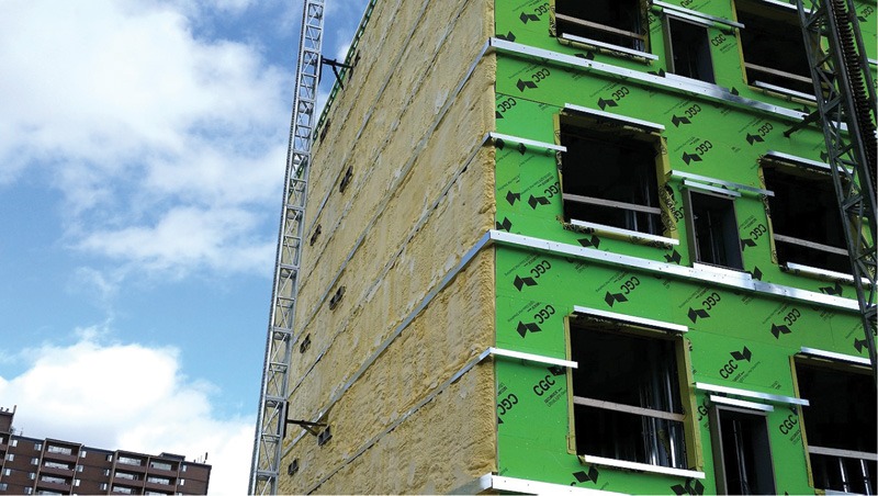 A building featuring green insulation on its exterior, showcasing modern energy-efficient construction techniques.