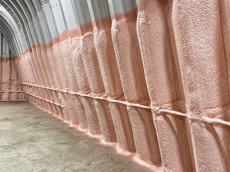 Interior corridor with textured pink walls and a metallic curved ceiling.