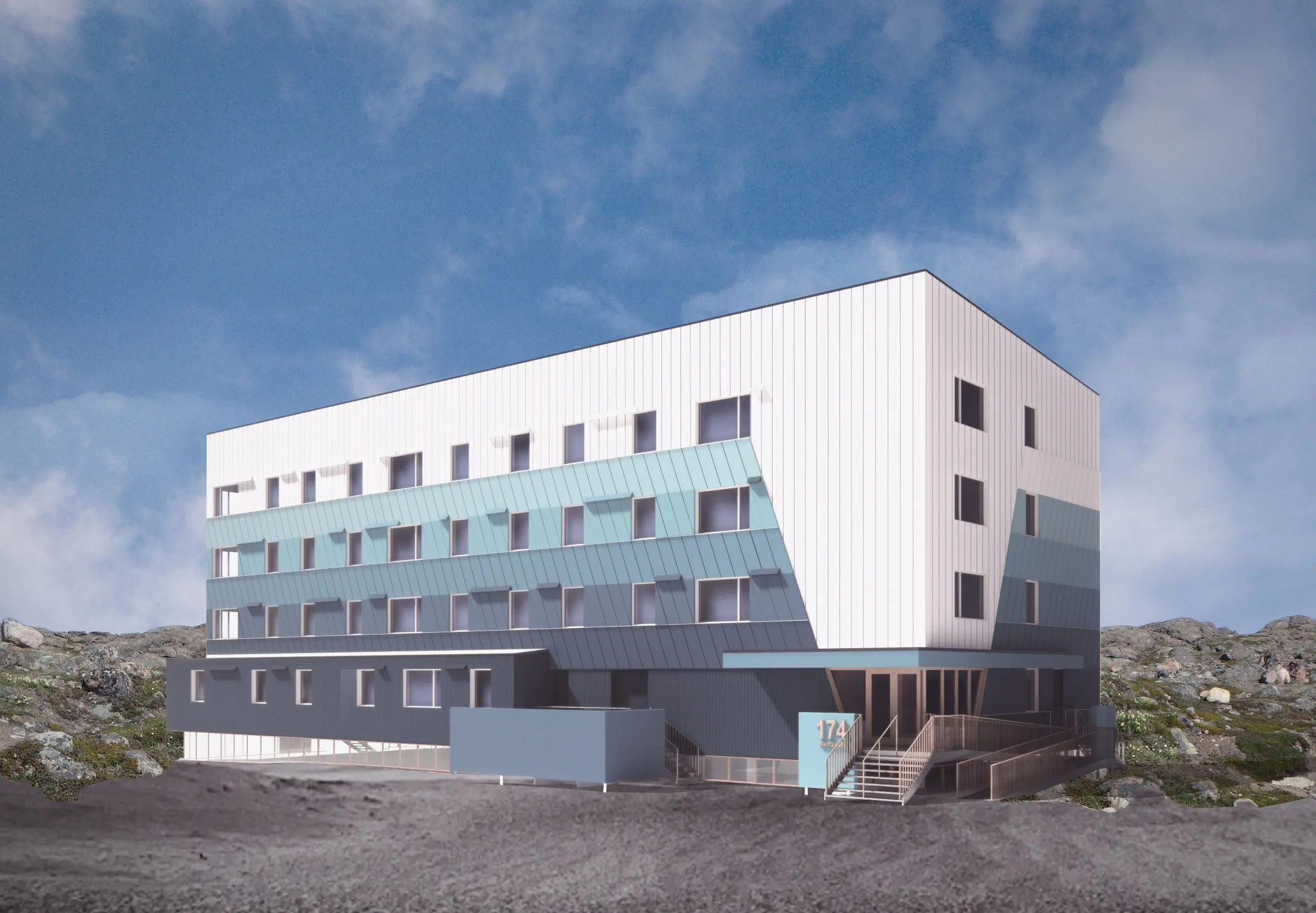 A modern, four-story building with a mix of white and teal panels, featuring angular design elements and a rocky landscape in the foreground.