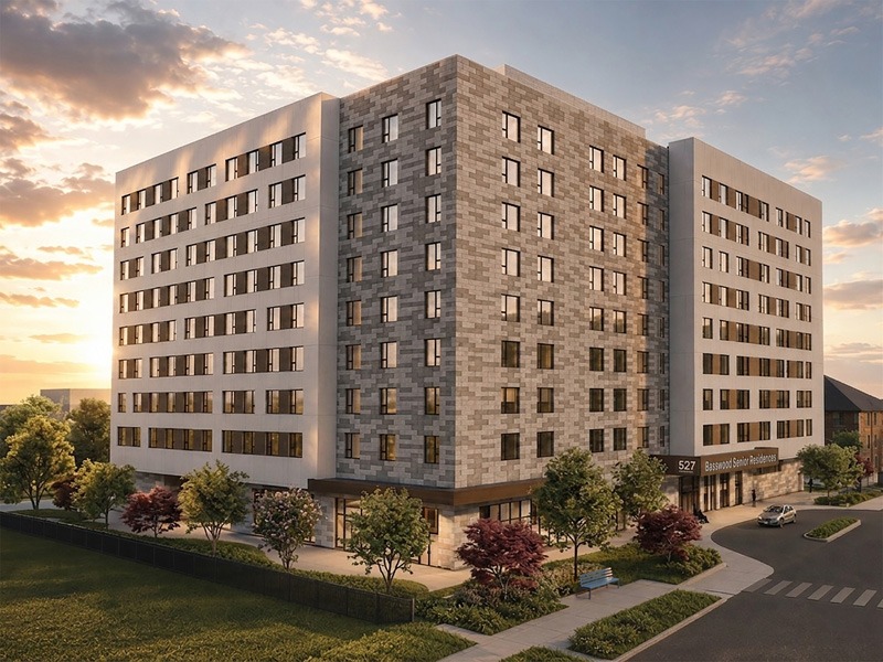 Modern multi-story Basswood Student Residence building with brick-patterned walls, rows of windows, and landscaped grounds at sunset.