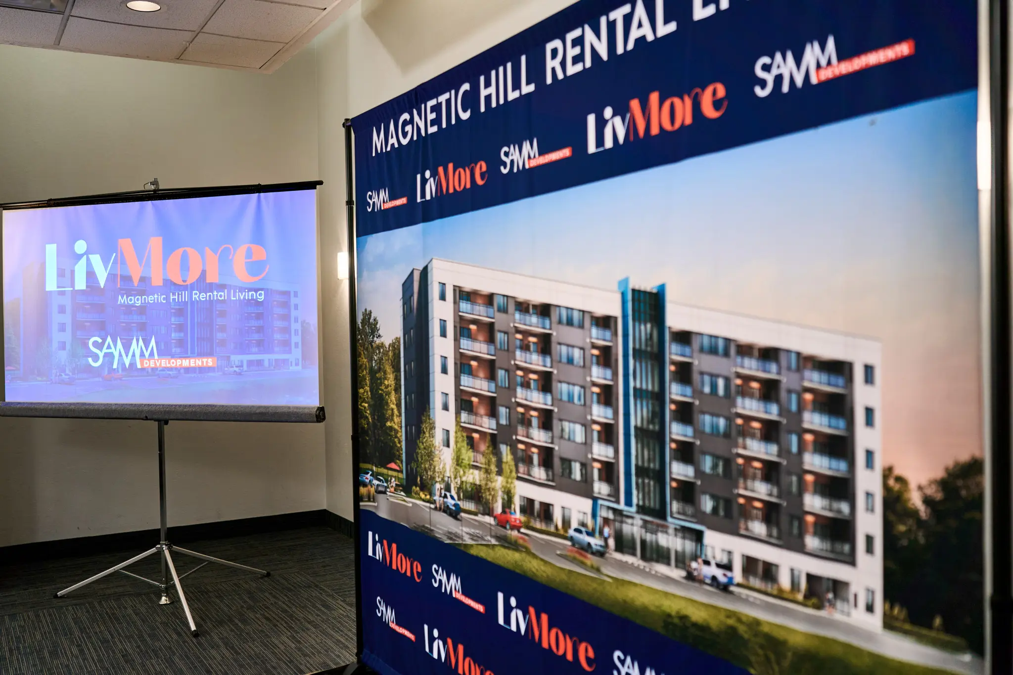 Indoor promotional displays for LivMore’s Magnetic Hill rental apartment development, showing a modern apartment-building rendering and company logos.